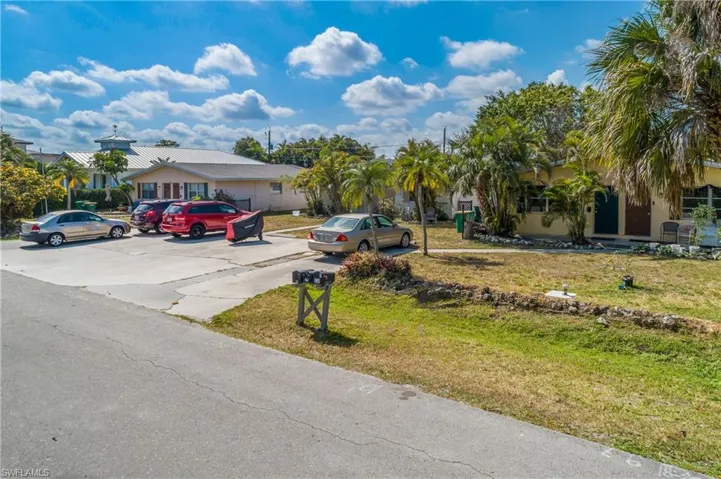 View of front of property featuring a front lawn and uncovered parking