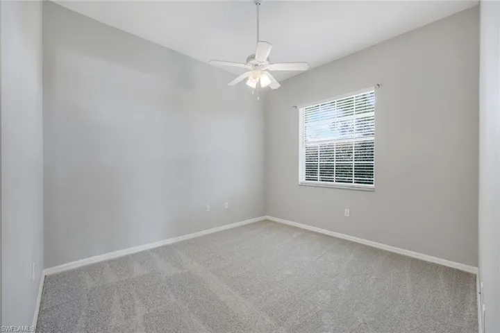 Carpeted empty room with baseboards and ceiling fan