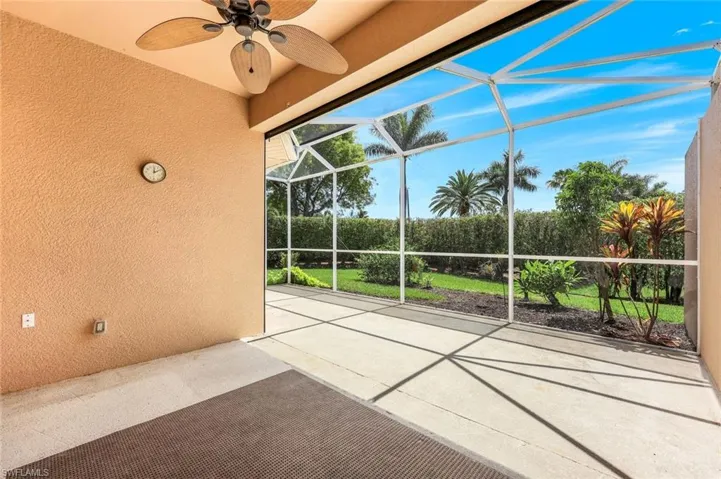 View of patio featuring a ceiling fan and glass enclosure
