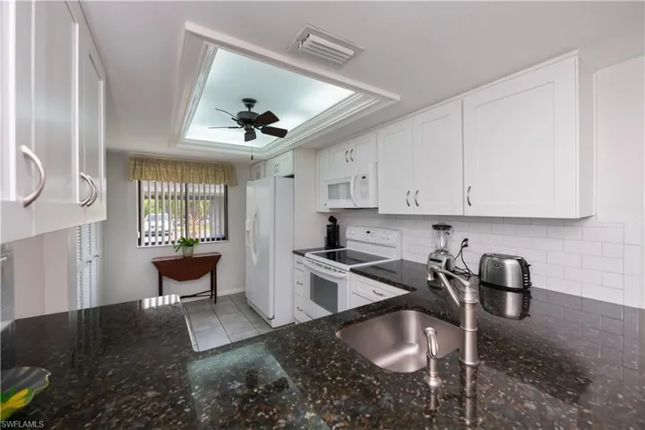 New white cheery  cabinets, dark granite counters and classic white subway backsplash