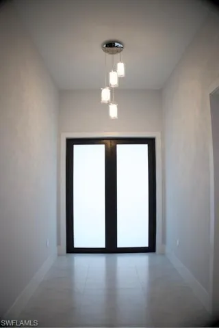 Doorway to outside featuring french doors and baseboards