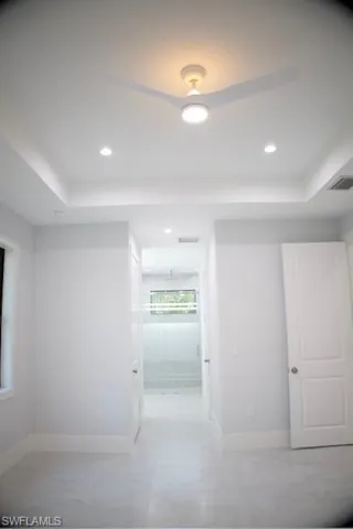 Hallway with a raised ceiling and recessed lighting