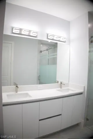 Bathroom with double vanity and a shower stall