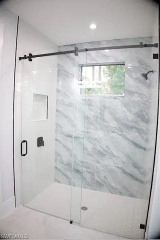 Bathroom featuring a marble finish shower