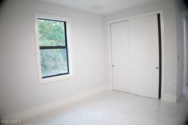 Unfurnished bedroom with baseboards and a closet