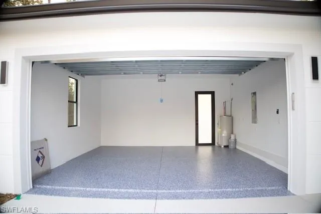 Garage featuring water heater and electric panel