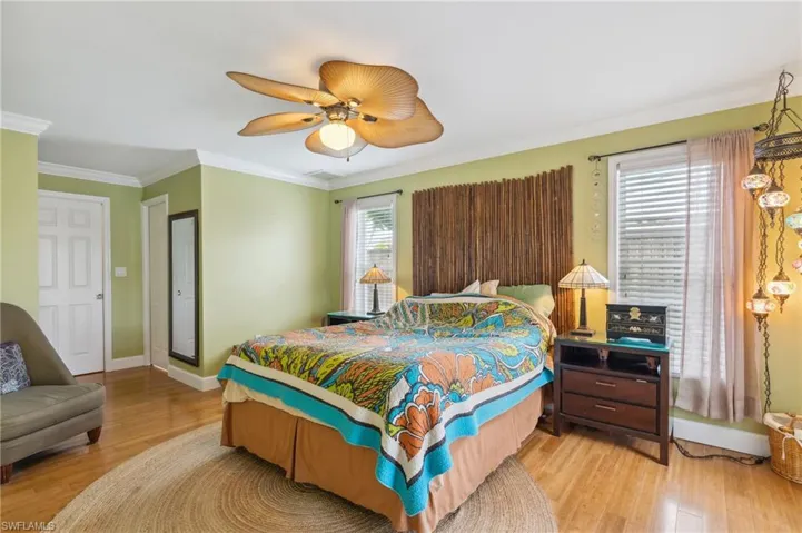 Bedroom with crown molding, light hardwood / wood-style flooring, and ceiling fan