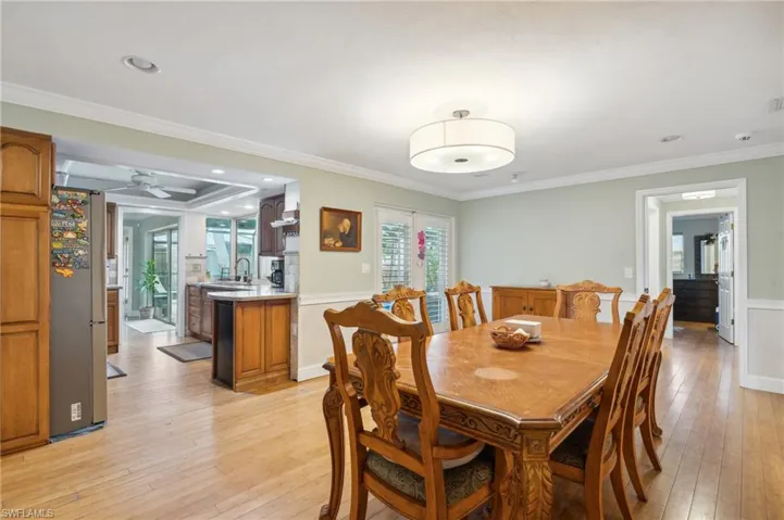 Dining area featuring light wood-type flooring, ceiling fan, crown molding, and sink