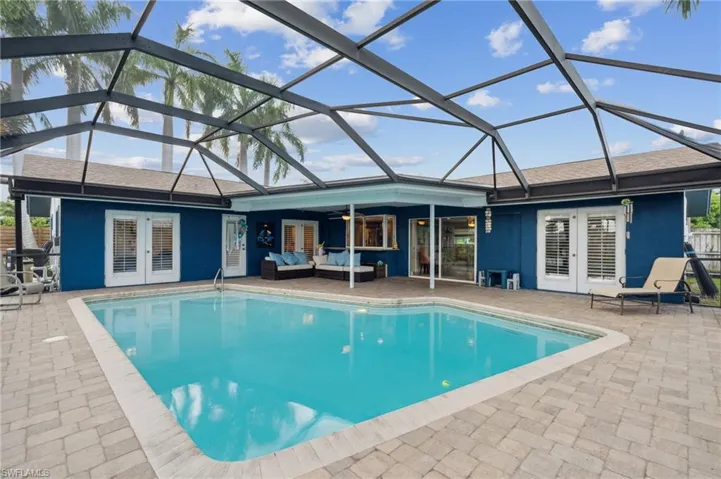 View of swimming pool featuring a lanai, a patio, and french doors