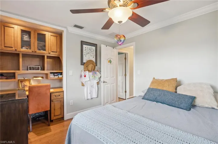 Bedroom with light wood-type flooring, crown molding, and ceiling fan