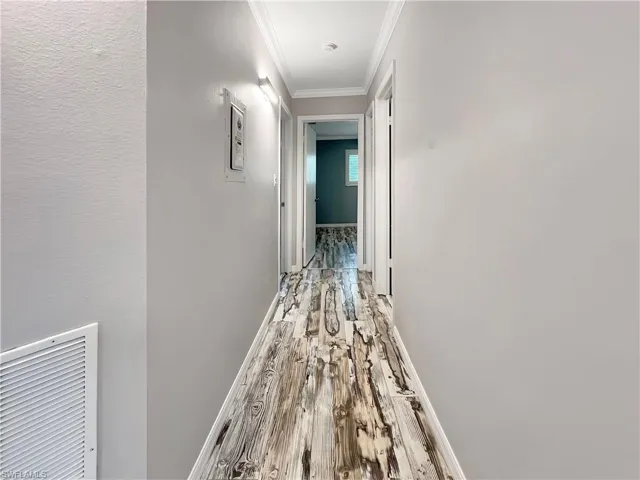Corridor featuring crown molding and hardwood / wood-style floors