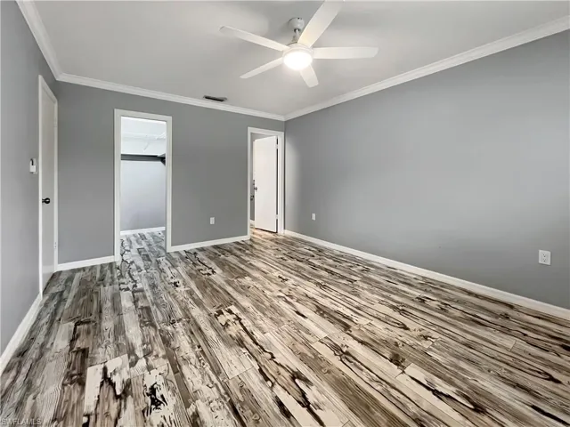 Primary bedroom featuring hardwood / wood-style floors, ceiling fan, a closet, and a walk in closet