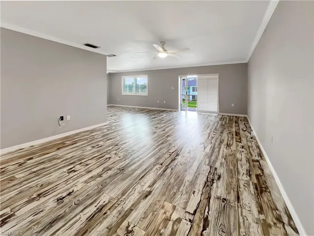 Great room featuring ceiling fan, light wood-type flooring, and crown molding