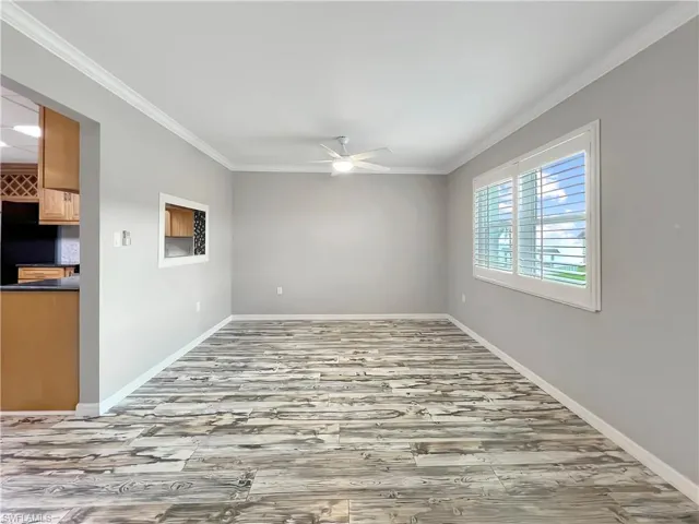 Dining room with wood-type flooring, crown molding, and ceiling fan