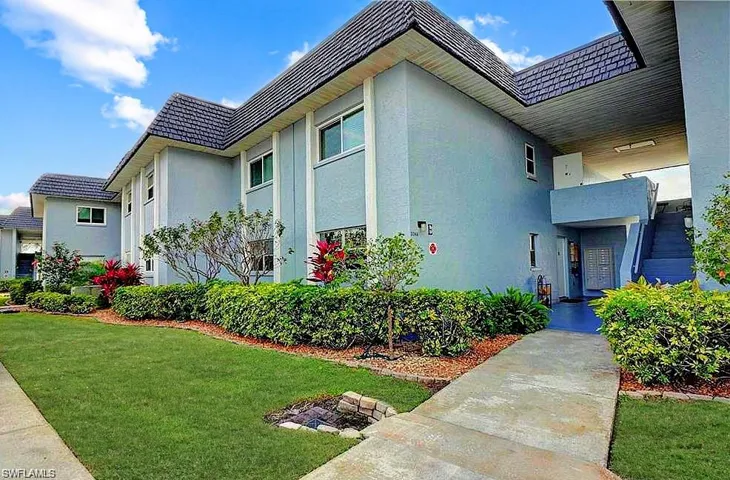 View of side of property with a balcony and a lawn