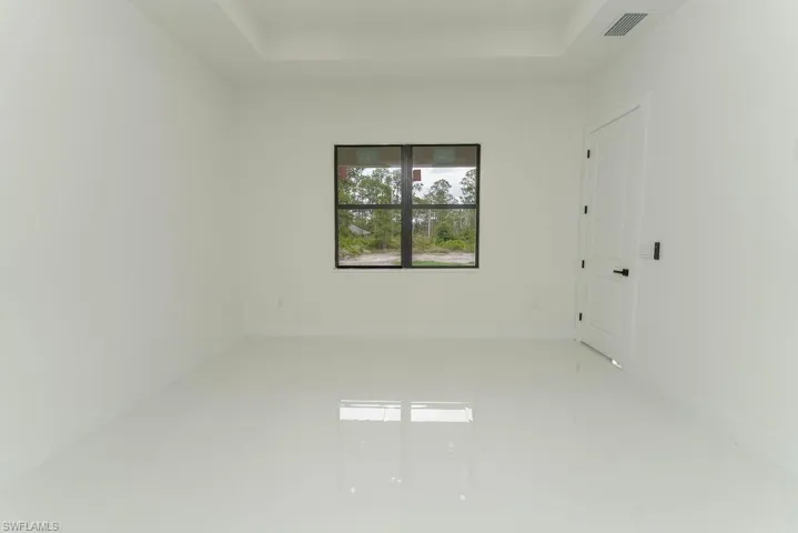 Unfurnished room with a raised ceiling