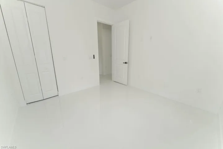 Unfurnished bedroom featuring light tile patterned flooring and a closet