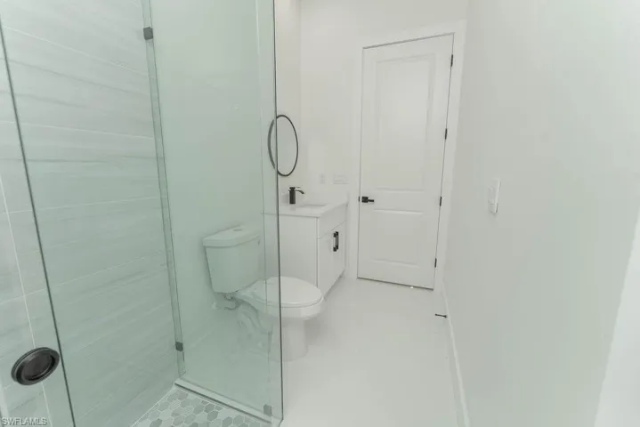 Full bathroom featuring vanity, toilet, tile patterned floors, and a stall shower