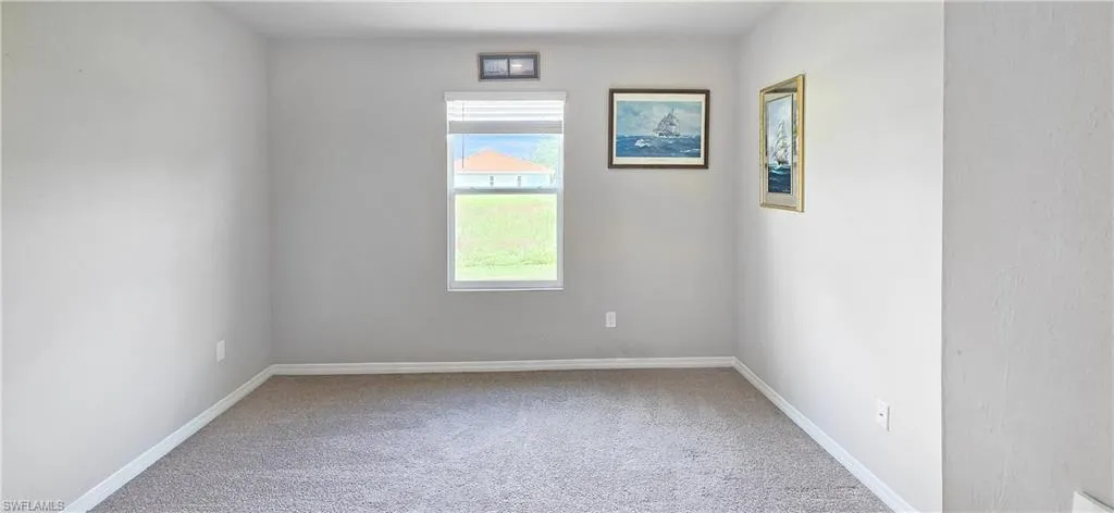 Neutral-toned room featuring a single window with blinds and gray carpeting