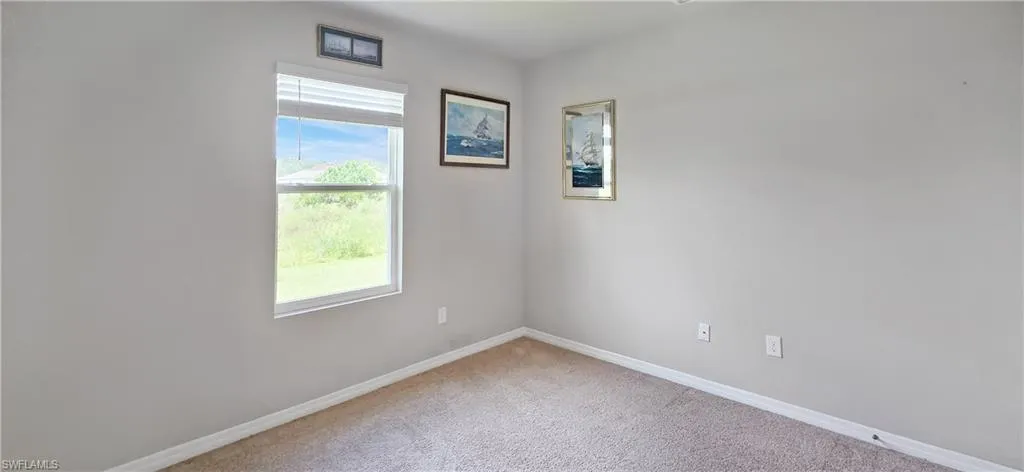 Light gray wall color with white baseboards and neutral carpet flooring