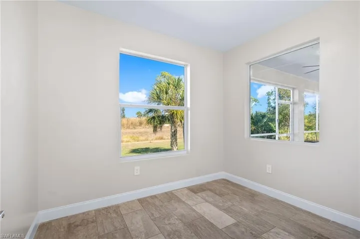 Spare room featuring baseboards and wood finish floors