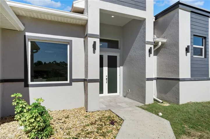 View of exterior entry with french doors and stucco siding