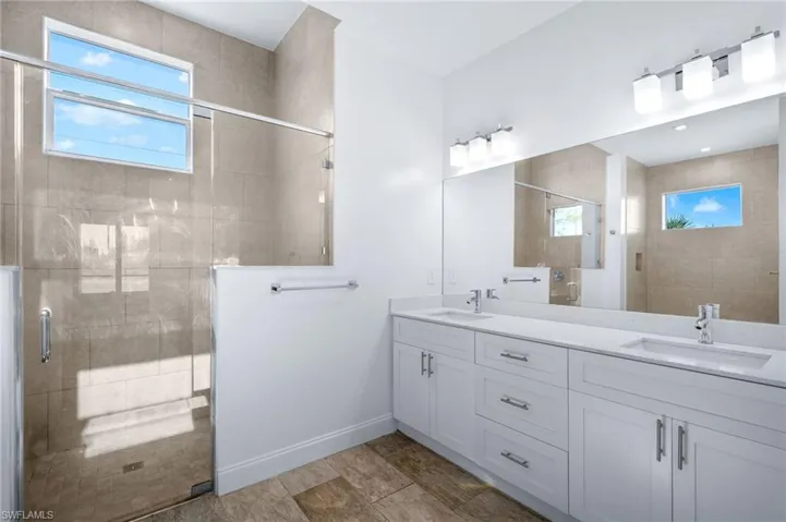 Bathroom with double vanity and a stall shower