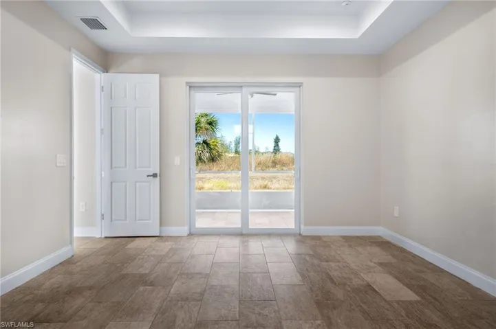 Empty room featuring a raised ceiling and wood tiled floors