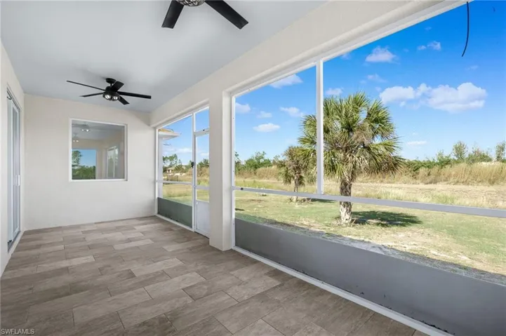 Unfurnished sunroom featuring ceiling fan