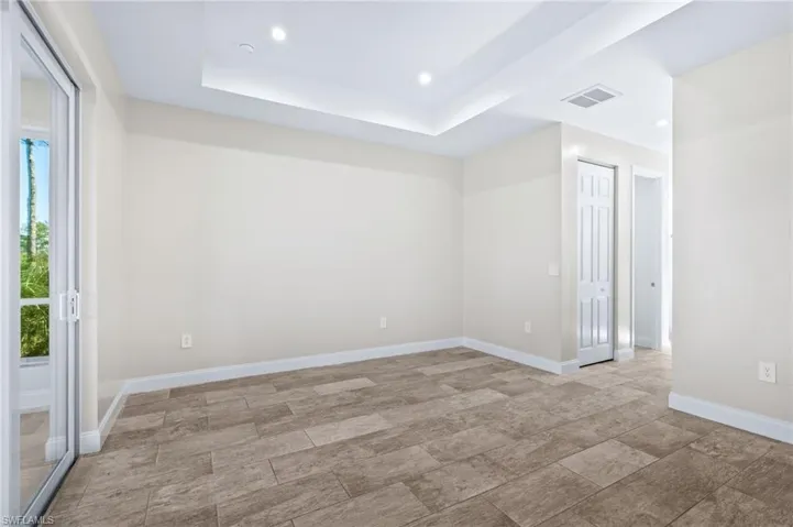 Empty room with a tray ceiling and recessed lighting