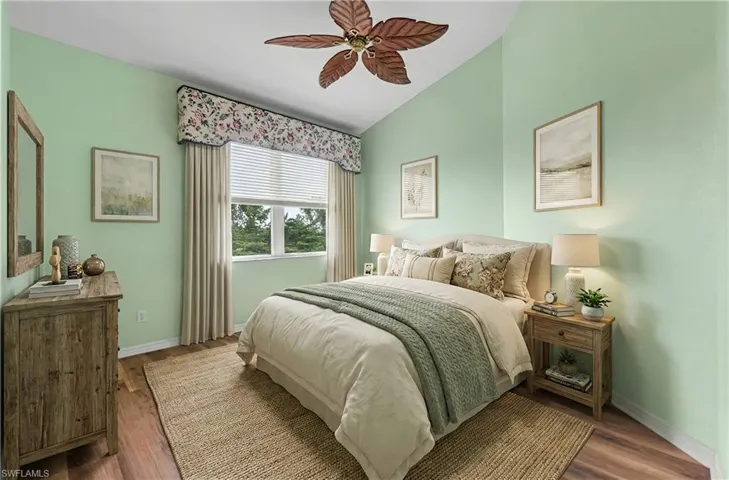 Bedroom featuring a ceiling fan, wood finished floors, and vaulted ceiling