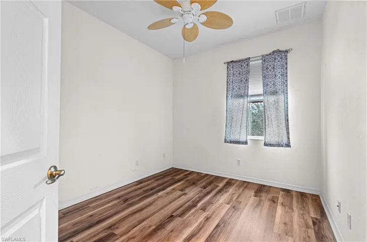 Spare room with wood finished floors and ceiling fan