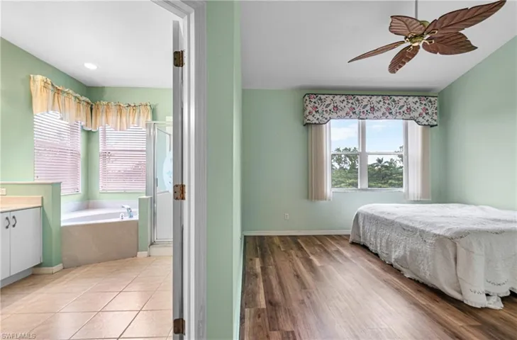 Bedroom with multiple windows, ceiling fan, and light wood-style floors