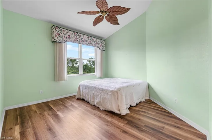 Bedroom featuring wood finished floors, a ceiling fan, and lofted ceiling