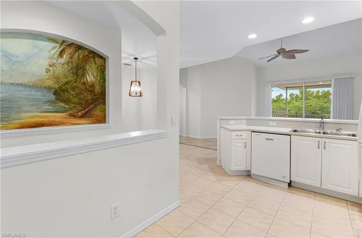 Kitchen with white dishwasher, white cabinetry, light tile patterned floors, pendant lighting, and ceiling fan