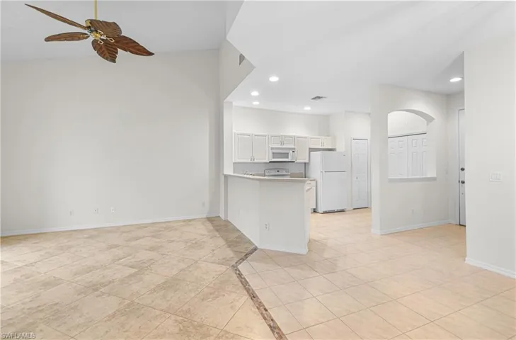Kitchen featuring a peninsula, recessed lighting, white appliances, ceiling fan, and open floor plan