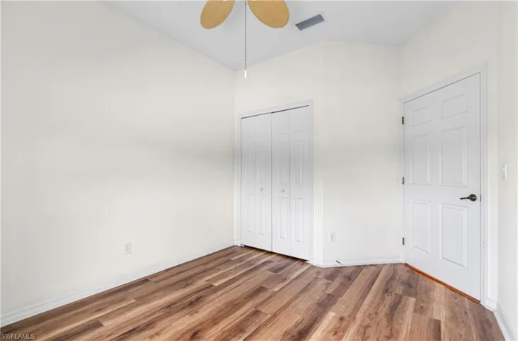 Unfurnished bedroom featuring wood finished floors, a closet, and ceiling fan
