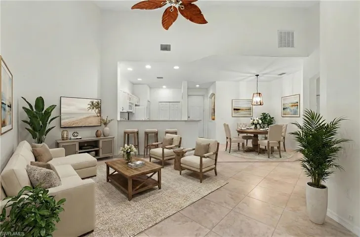 Tiled living room featuring a high ceiling, recessed lighting, and ceiling fan