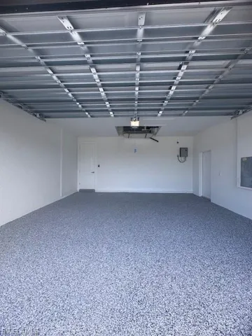 Garage featuring electric panel and a garage door opener