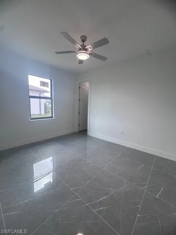 Spare room with baseboards and a ceiling fan