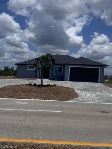 View of front of property with a garage and decorative driveway