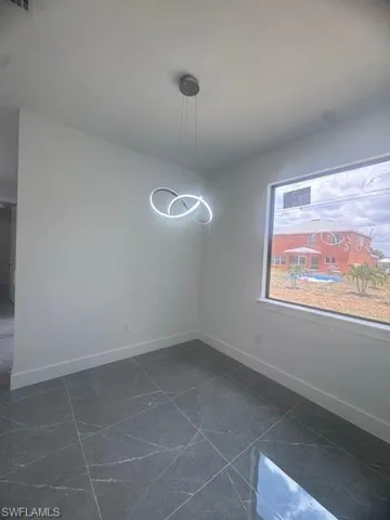 Unfurnished dining area featuring baseboards