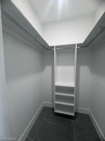 Spacious closet with dark marble finish floors