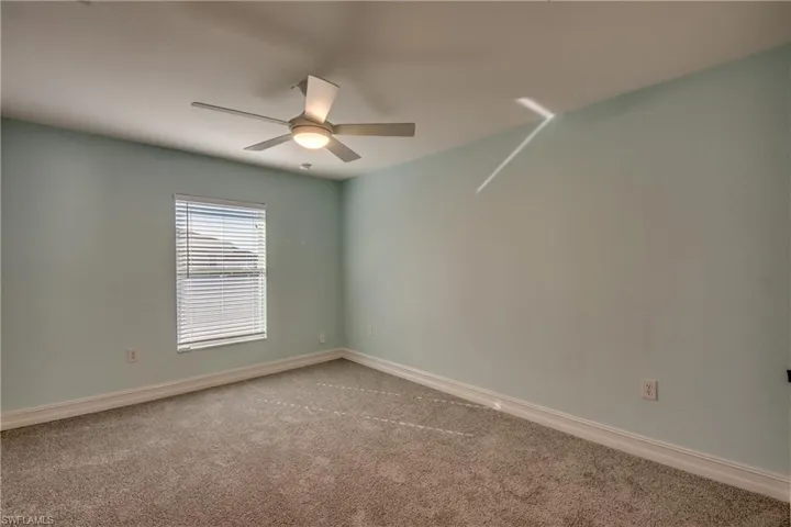 Unfurnished room with ceiling fan and carpet floors