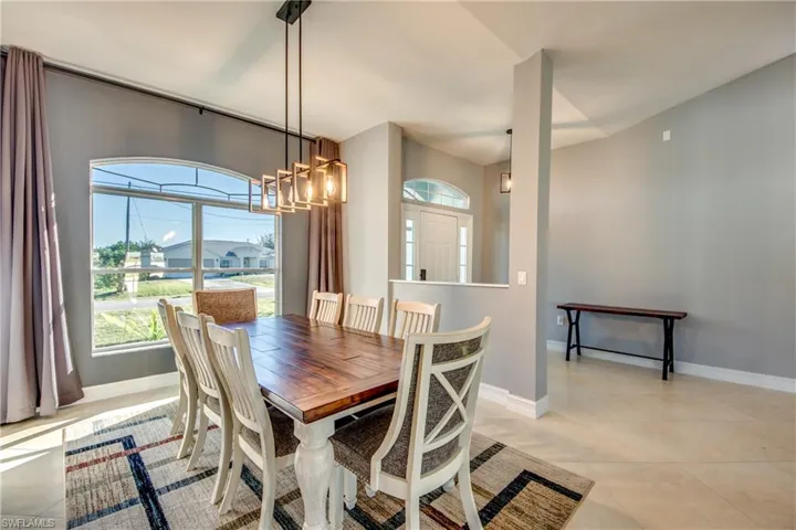 Dining space with a notable chandelier and light tile patterned flooring
