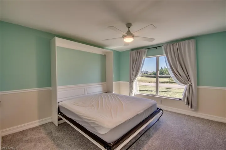 Bedroom with Murphy Bed, ceiling fan and carpet floors