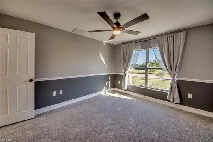 Empty room featuring carpet flooring and ceiling fan