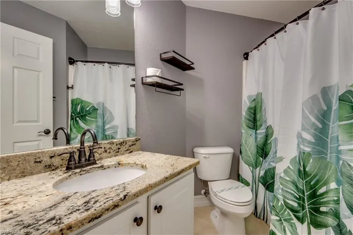 Bathroom featuring tile patterned floors, vanity, and toilet