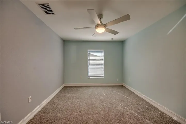 Spare room with ceiling fan and carpet