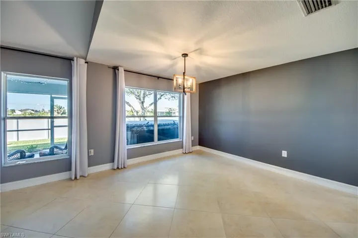 Nook with a notable chandelier, a healthy amount of sunlight, light tile patterned floors, and a textured ceiling